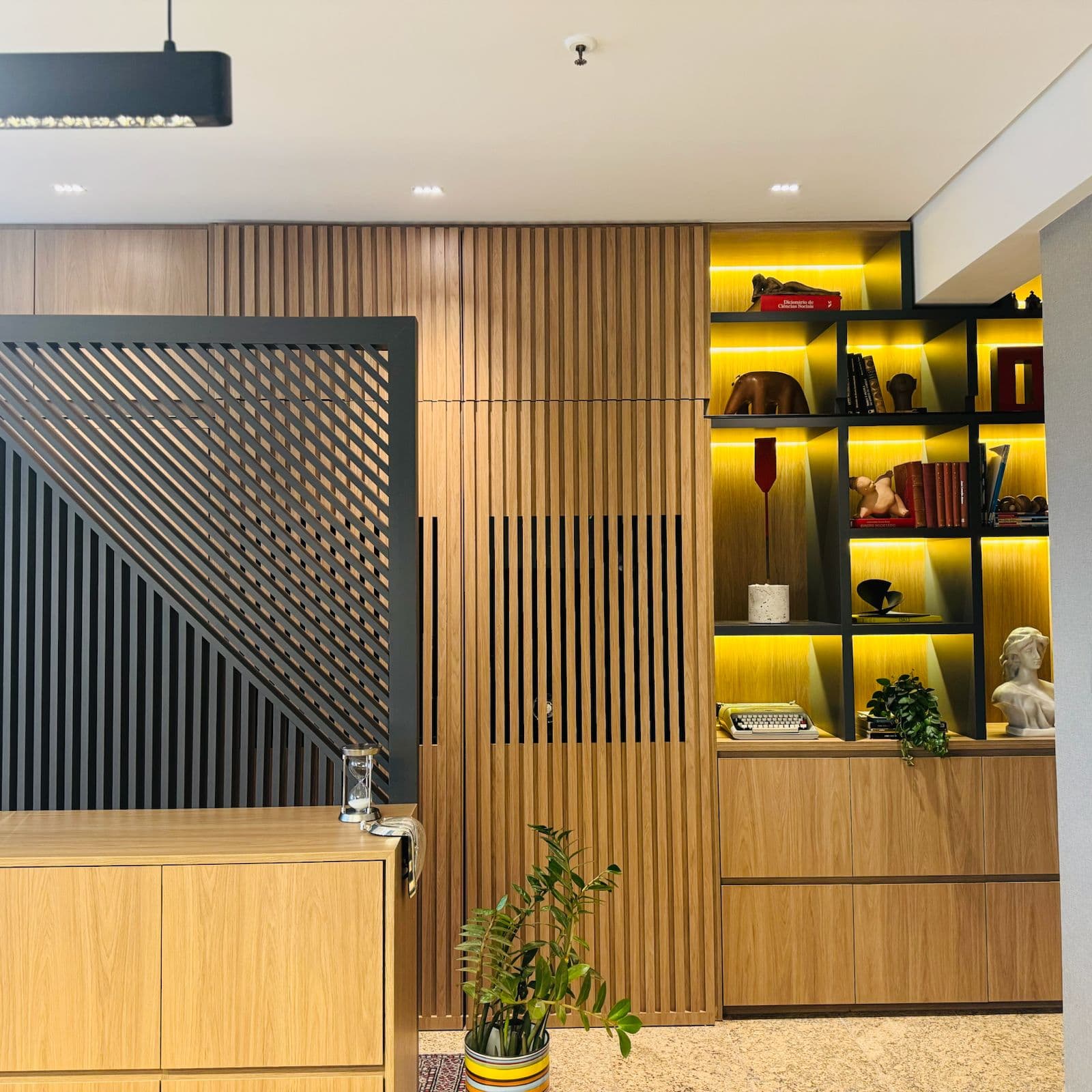 Espaço de trabalho com estante, acervo e decoração do escritório.